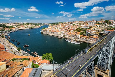 View of Porto city and Douro river with moored sailing ship and Dom Luis bridge I from famous