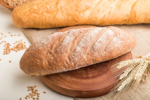 Different kinds of fresh baked bread on a white wooden background. side view, close up, selective