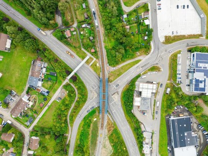 Aerial view of a road crossing with railway bridge in urban surroundings, track construction, rail