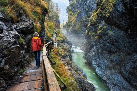 The River Lammer in the Lammerklamm gorge. A hiker on her way through the gorge. Autumn. Scheffau,