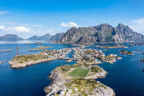 Aerial view over fishing village Henningsvaer, football stadium on rocky island, Lofoten, Norway,