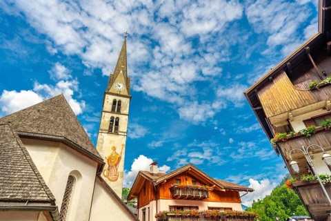 Picturesque view of alleghe village in the italian dolomites, featuring a church tower, traditional