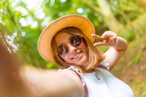 Personal point of view of a beauty young caucasian woman gesturing success with fingers while