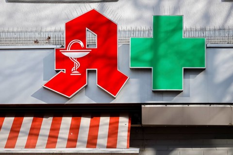 Pharmacies are systemically relevant in the corona crisis, red logo and green cross on the facade