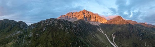 Panorama, rocky mountain peak Porze and green mountain landscape with river valley at sunrise,