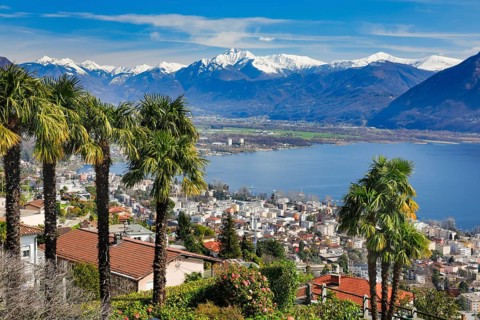 View over the city of Locarno and Lake Maggiore with snow-capped mountains in the background,