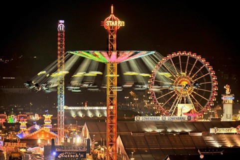 View over the Wies'n at night with illuminated carousel, Ferris wheel, stalls, beer tents and