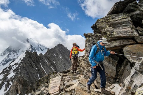 Two mountaineers on a hiking trail secured with a rope, glaciated summit Großer Möseler in the