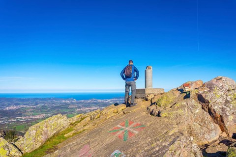 A male hiker on the top of Mount Adarra in Urnieta. Gipuzkoa, Basque Country