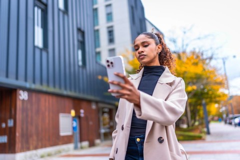 Beauty african woman using smartphone to find a direction in the city