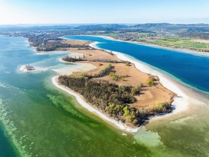 Aerial view of the Mettnau peninsula at low tide and spring-like vegetation, on the horizon the