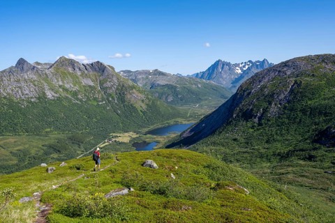 View of mountain landscape, mountaineer on hiking trail to the summit of Rundfjellet, Svolvaer,