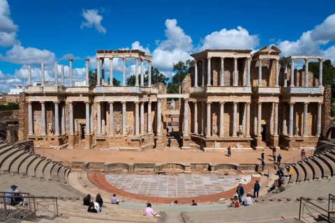 Large Roman theatre with impressive ancient columns and numerous spectators in the rows of seats