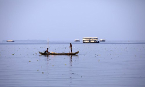 Fisherman on a small boat on the Vembanad Lake, canal system of the backwaters, Kerala, India, Asia
