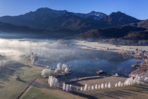 Aerial view of a lake in front of mountains in winter, hoarfrost, morning light, view of