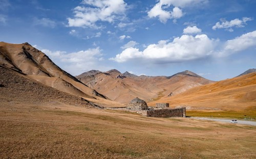 Historic caravanserai Tash Rabat from the 15th century, with yellow hills, Atbashy district in the