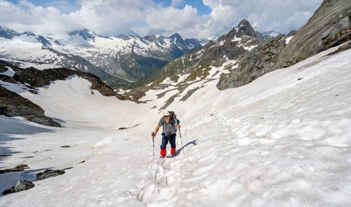 Mountaineer crossing a snowfield, ascent to the Nördliche Mörchnerscharte, mountain peak with snow