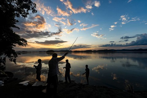 People fishing in the Brahmaputra river at the background during the sunset, in Guwahati, Assam,
