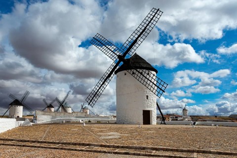 Row of white windmills on a sandy ground with a cloudy sky, Campo de Criptana, Ciudad Real