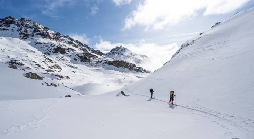 Atmospheric clouds in a wintry mountain landscape, ski tourers on the ascent to Porta d'Es-cha,