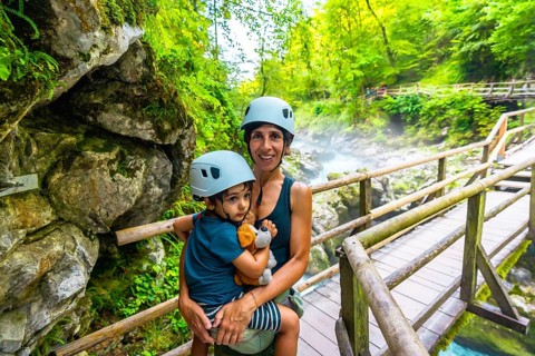 Mother holding her son while exploring the beautiful vintgar gorge near bled in slovenia, both