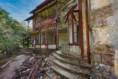 Sky replaced, Abandoned, damaged house with wooden structure, stone staircase and surrounding
