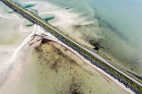 Aerial view of a bridge over turquoise sea at a sandy beach, fjord Grunnforfjorden, Lofoten