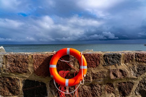 The city harbour of Sassnitz, island of Rügen, pier, harbour dam, dark rain clouds, lifebuoy,