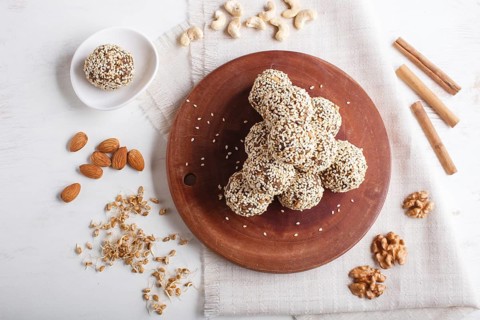 Energy balls cakes with almonds, sesame, cashew, walnuts, dates and germinated wheat on wooden