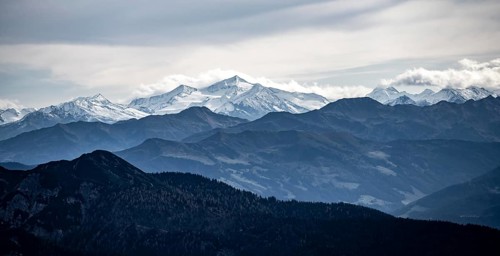 View of the Alpine foothills and the main Alpine ridge with snow-covered peaks, from the Austrian