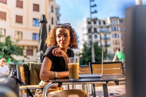 Beauty young arab woman drinking coffee using laptop in an outdoor cafeteria