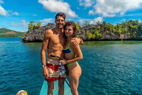 Couple enjoying a snorkeling trip in coron island, philippines, embracing on a traditional bangka