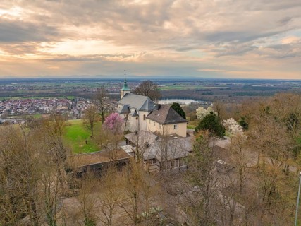 Panoramic view of a church with a view of the village and a cloudy landscape in the background,