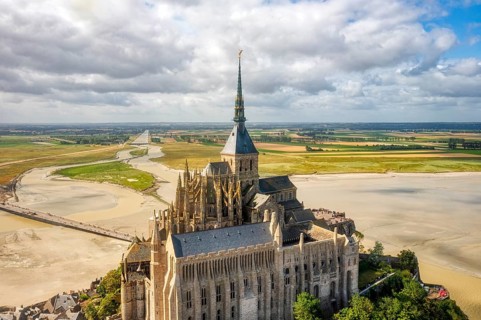 Aerial view of the imposing abbey in an extensive sand and water landscape, Le Mont-Saint-Michel