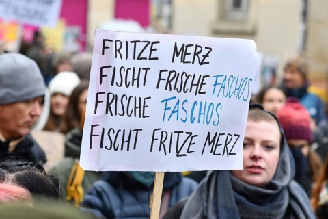 Heidelberg, Germany - February 12th 2025: Person holding up sign about CDU politian Merz and