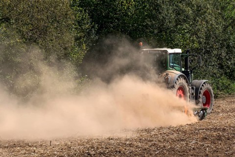 Tractor with plough digging up dried-out soil, large cloud of dust, dust, dry, field, earth,
