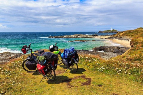 Two e-bikes on the South West Coast Path, coastline with Godrevy Island and lighthouse, landscape