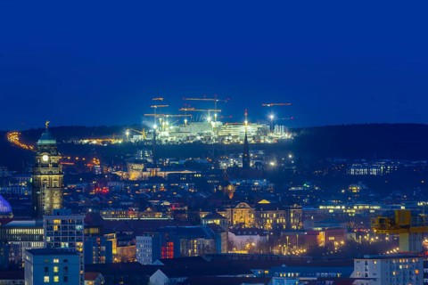 City centre of Dresden at blue hour, on the horizon the illuminated construction site of Infineon,
