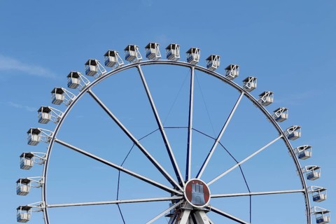 Ferris wheel with Hamburg city coat of arms against a blue sky in summer on Hamburg Cathedral,