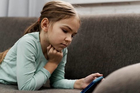 Little girl playing smartphone home