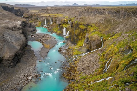 Waterfalls and a turquoise blue river flowing through a canyon, Sigöldugljúfur, long exposure,