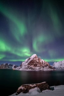 Green northern lights reflected in fjord, steep mountains, aurora borealis, winter, Reine,