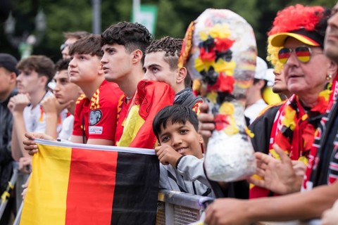 Spanish and German football fans next to each other in the front row of the fan zone at the