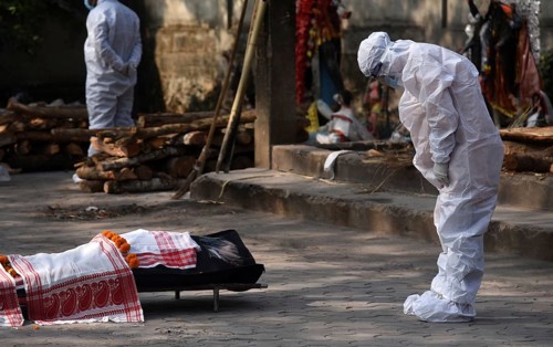 Family members wearing PPE kit performing last rites of a person who died of COVID-19 coronavirus
