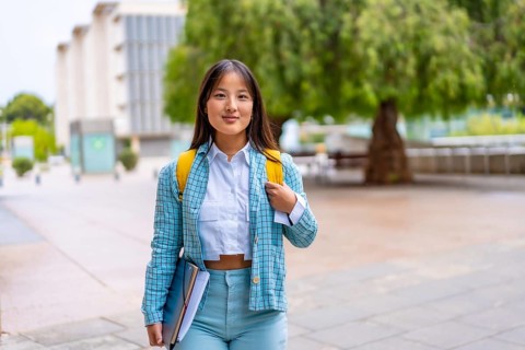 Portrait of a chinese university student in the campus standing proud looking at camera