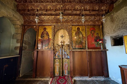An altar in a church with religious icons, carved wood and candle lighting, Apokalipsis Monastery,