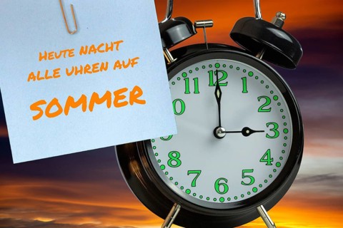 (Photomontage) Summer time changeover Symbolic image: Alarm clock in front of evening sky and text