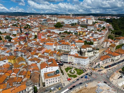 City view with red tiled roofs, densely built-up buildings and a blue sky with clouds, aerial view,