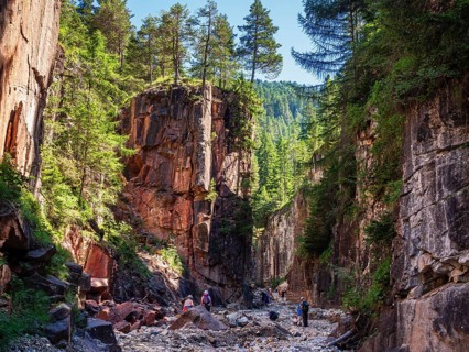 GEOPARC Bletterbach canyon, layers of sediments, stratum, people hike inside the gorge, Aldein,