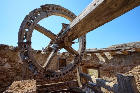 Large wooden cogwheel and wooden beams in an abandoned mill, under the open sky, windmill, ruin,